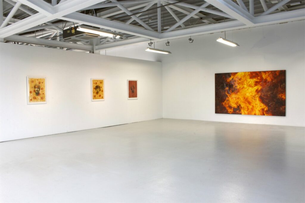 Sala del Centro Párraga con dos grandes óleos de fuego de Torregar en la exposición Arde Occidente