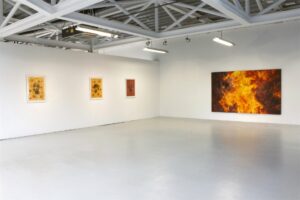 Sala del Centro Párraga con dos grandes óleos de fuego de Torregar en la exposición Arde Occidente